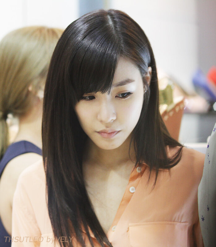 woman in peach shirt looking down