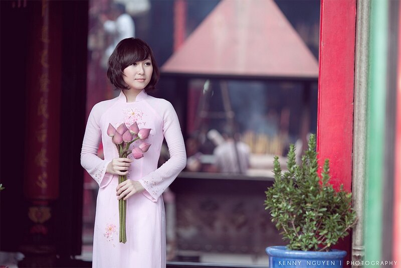 Woman in pink ao dai holding lotus