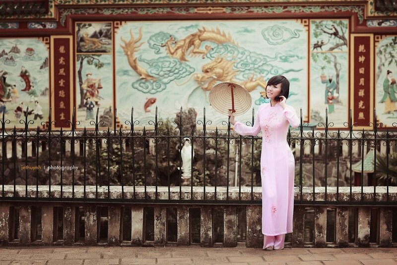 Woman in pink ao dai with conical hat