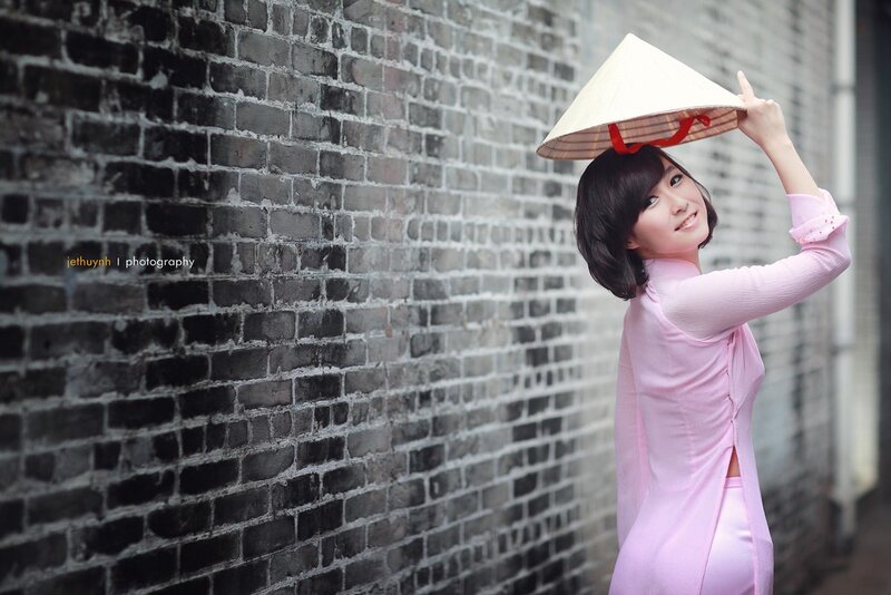 Woman in pink ao dai with conical hat