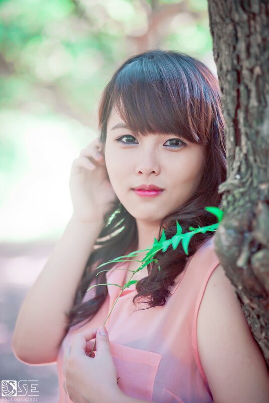 woman in pink by a tree