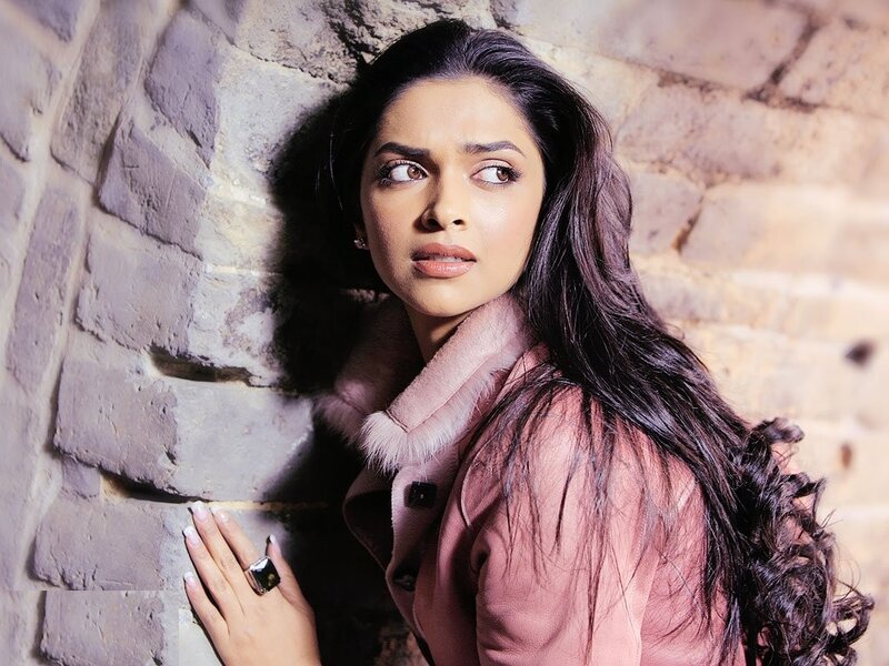 woman in pink coat against brick wall