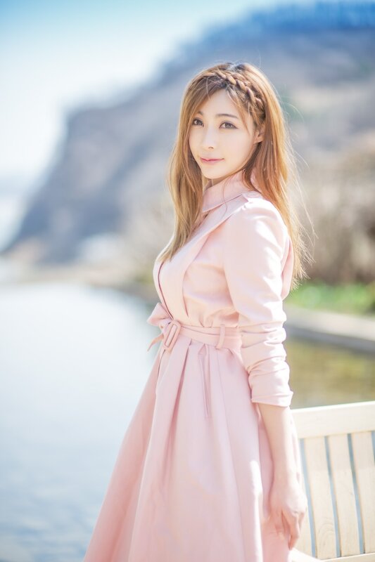 woman in pink coat by water