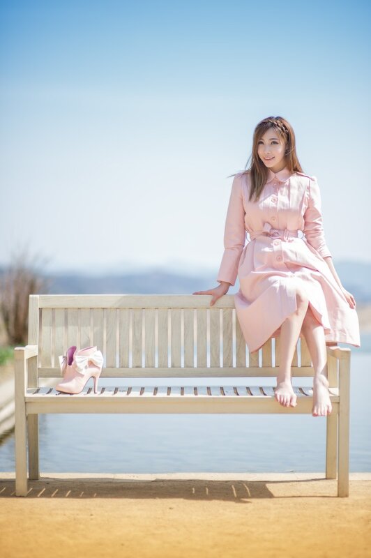 Woman in pink coat on bench