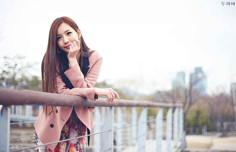 woman in pink coat on bridge