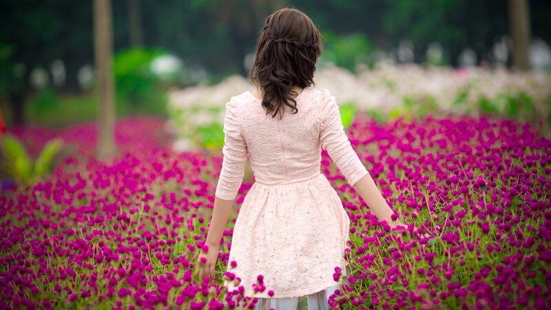 Woman in pink dress among flowers