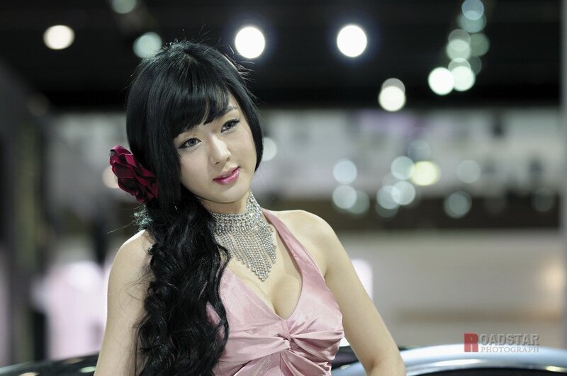 Woman in pink dress at auto show