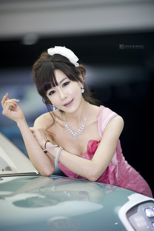 woman in pink dress at car show
