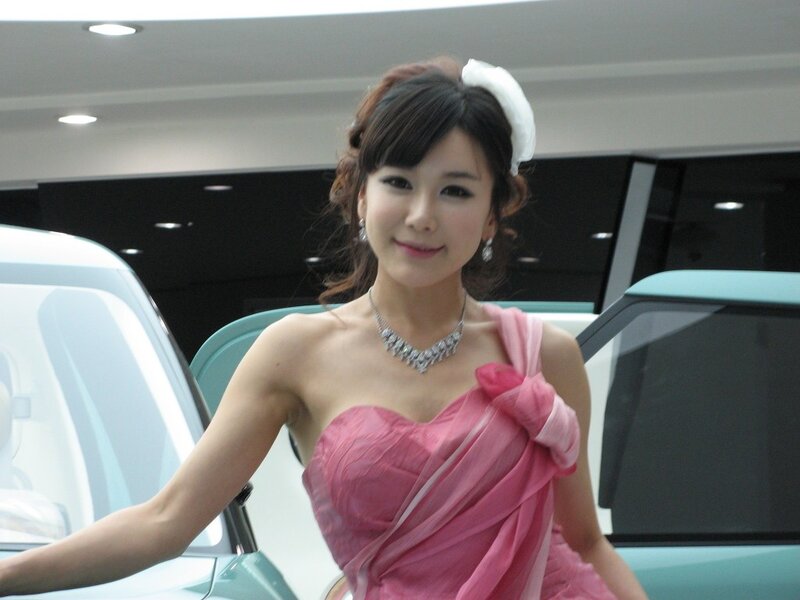 Woman in pink dress at car show