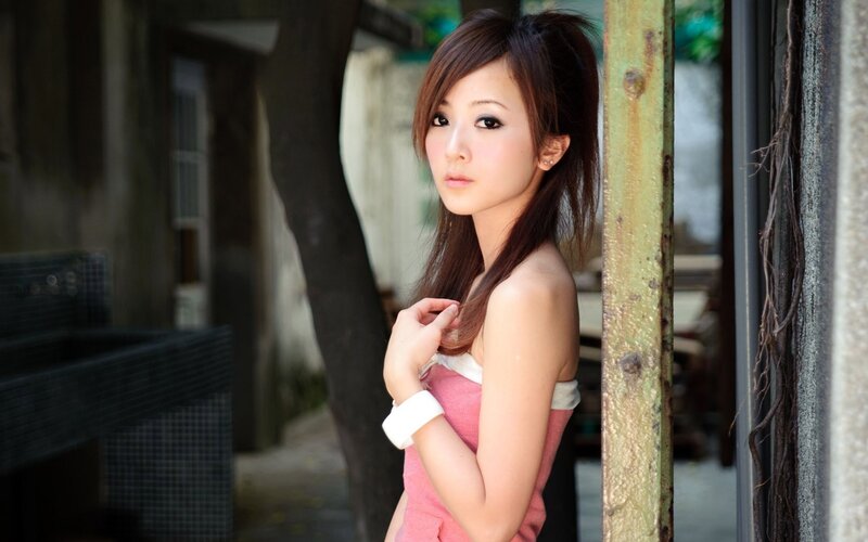 woman in pink dress by a post