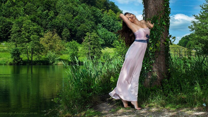 Woman in pink dress by lake