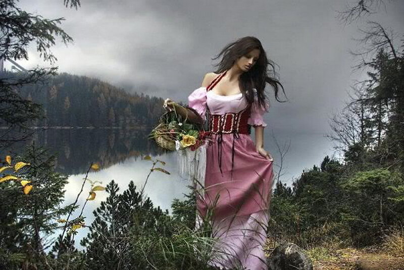 Woman in pink dress by lake