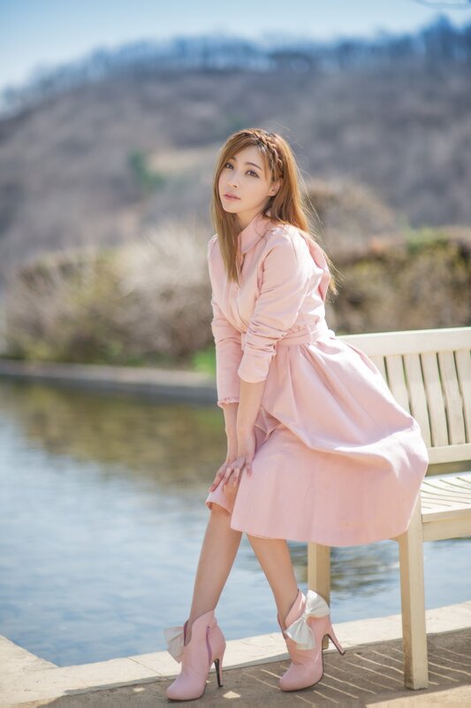 Woman in pink dress by the water