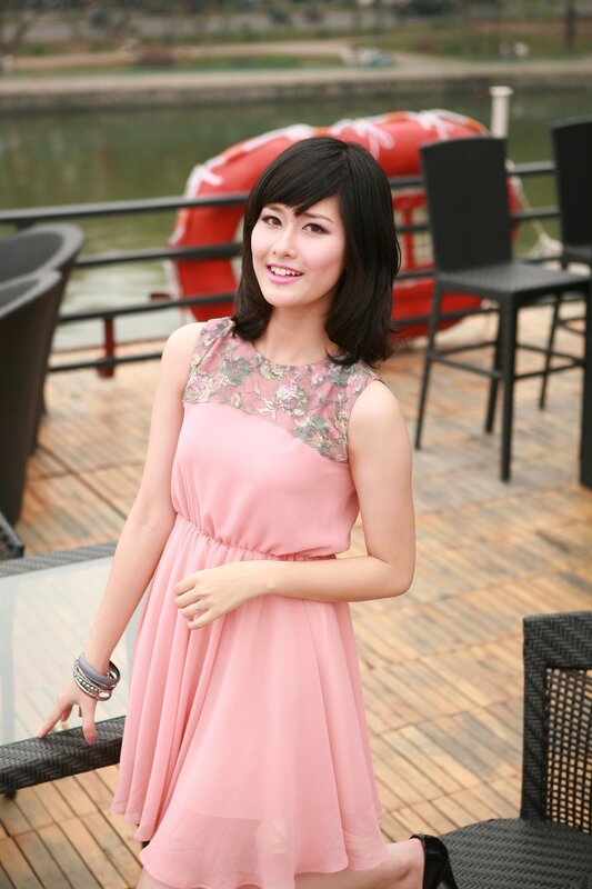 Woman in pink dress by water