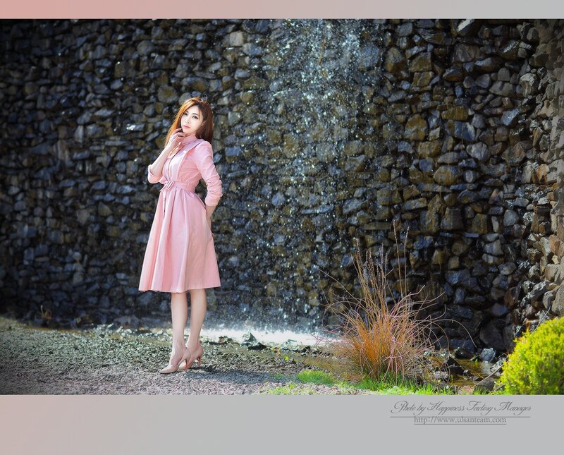 Woman in pink dress by waterfall