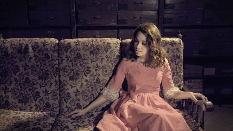 woman in pink dress on floral couch