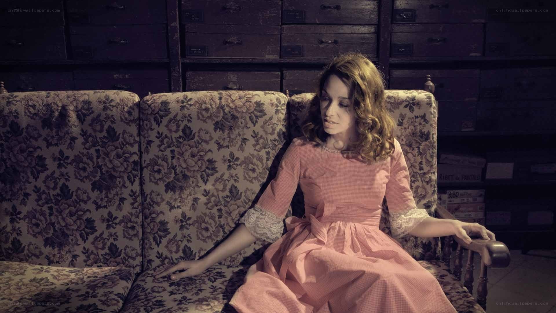 woman in pink dress on floral couch