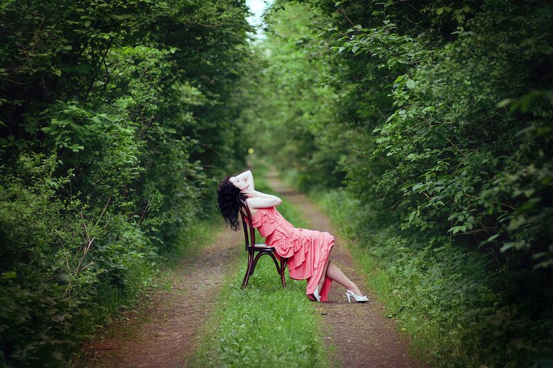 Woman in pink dress on forest path