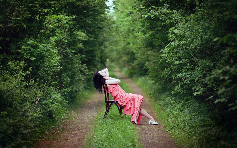 Woman in pink dress on forest path