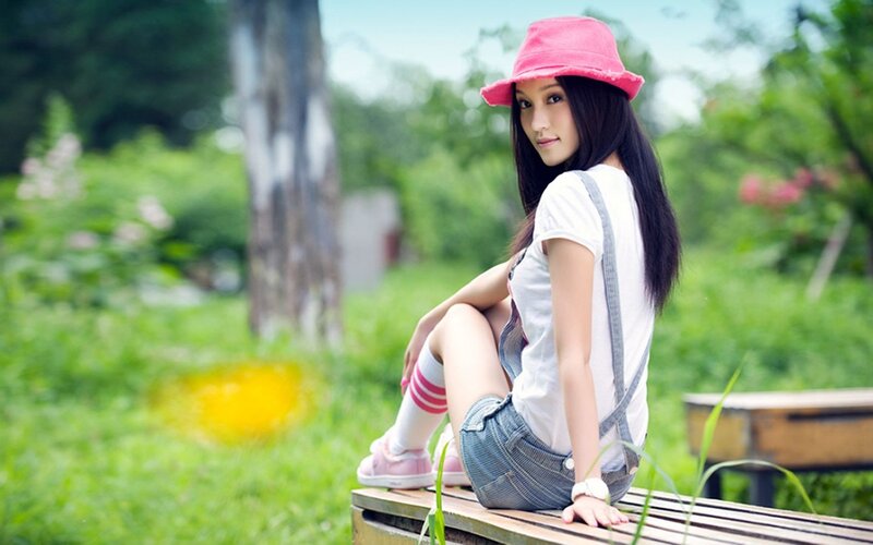 woman in pink hat sitting on bench