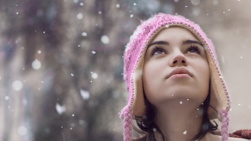 woman in pink hat watching snow