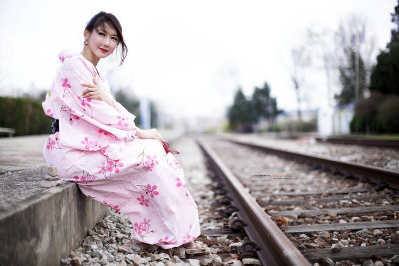 Woman in pink kimono on train tracks
