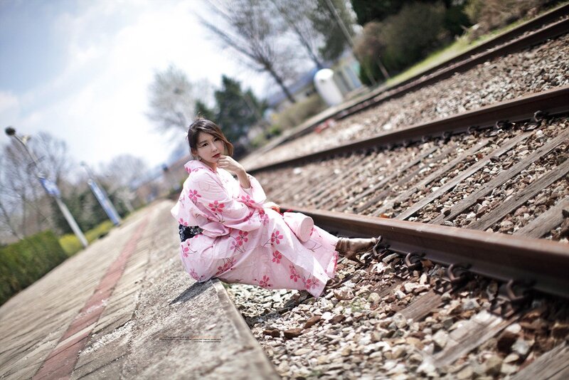 Woman in pink kimono on train tracks