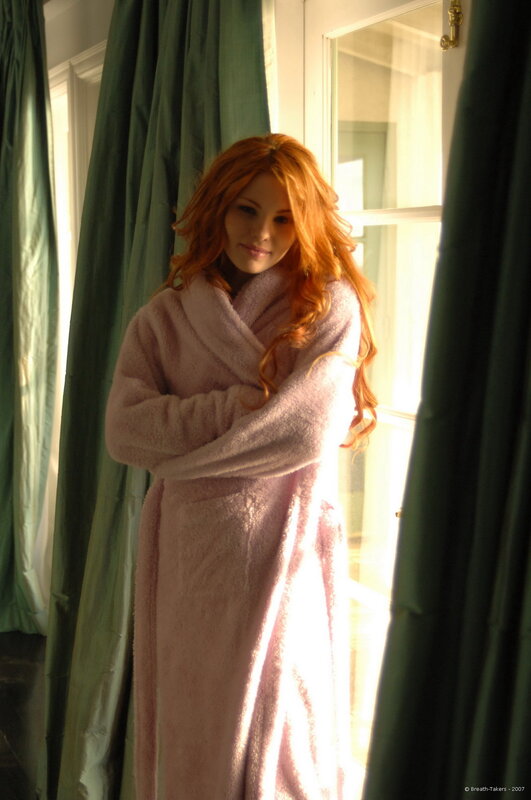 Woman in pink robe by window