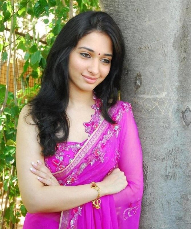 woman in pink sari leaning on tree