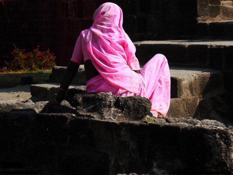 Woman in pink sari sitting on steps