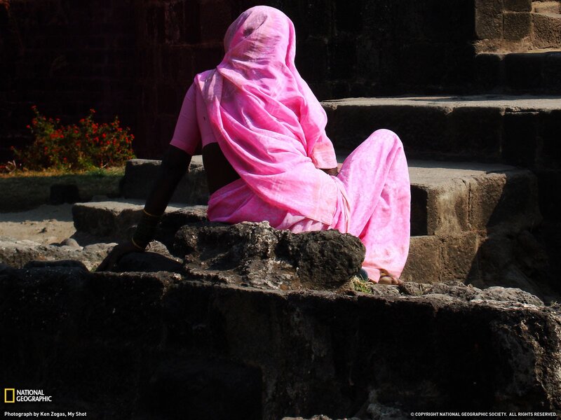 Woman in pink sari sitting on steps