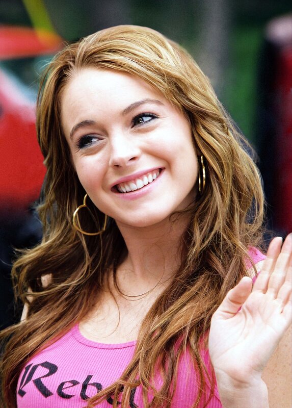 woman in pink shirt waving