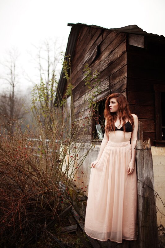 woman in pink skirt by cabin