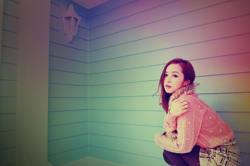 woman in pink sweater by wall