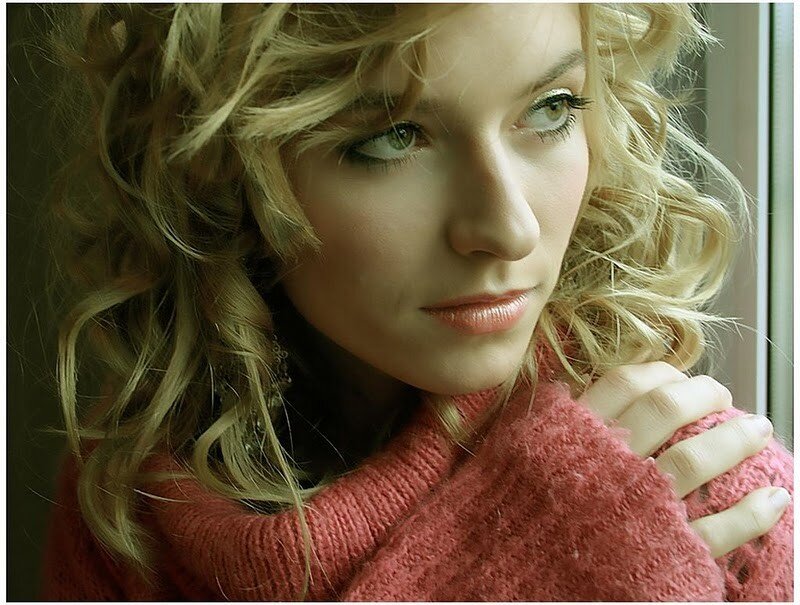 woman in pink sweater by window