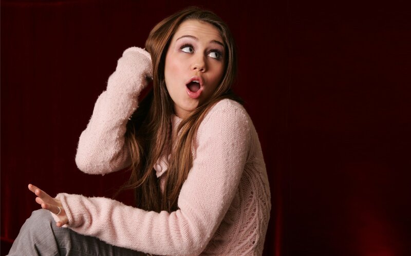 woman in pink sweater surprised