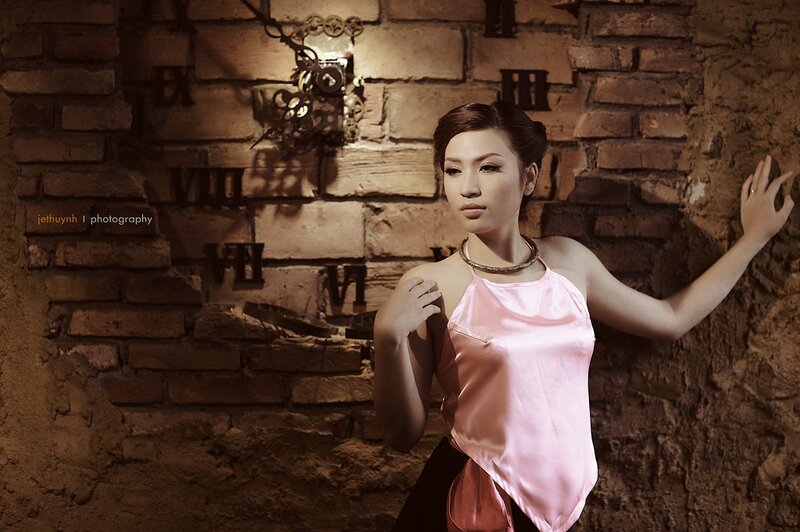 woman in pink top against brick wall