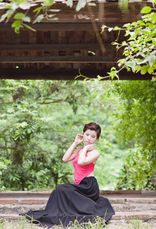 Woman in pink top sitting on steps
