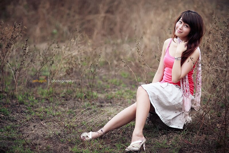 Woman in pink top sitting outdoors