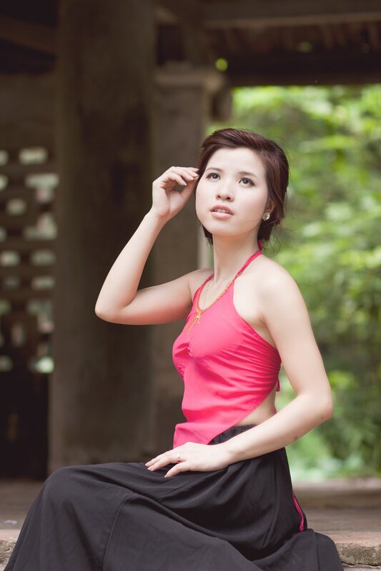 woman in pink top sitting outside
