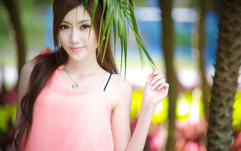 woman in pink top with palm leaf