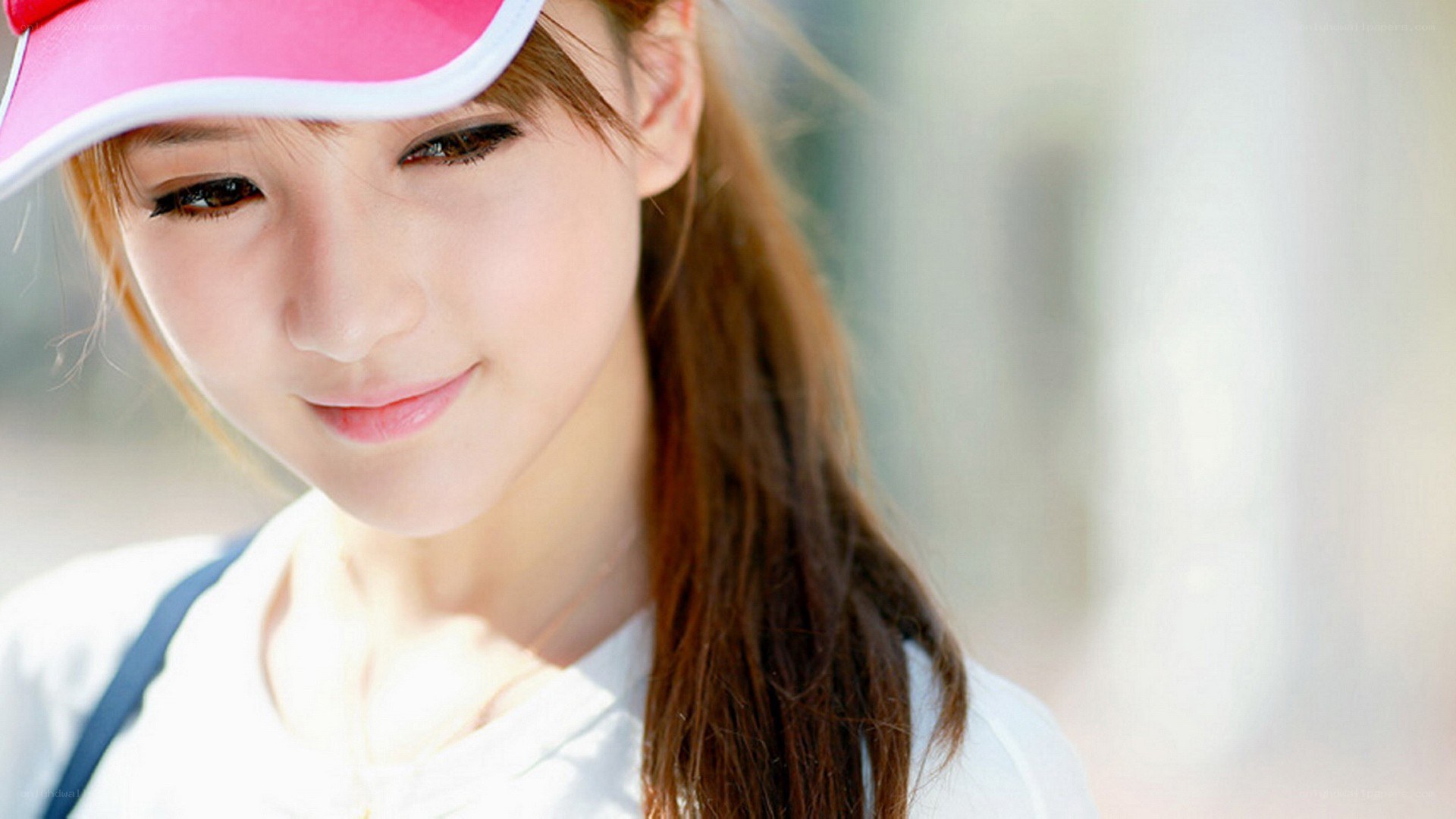 woman in pink visor smiling