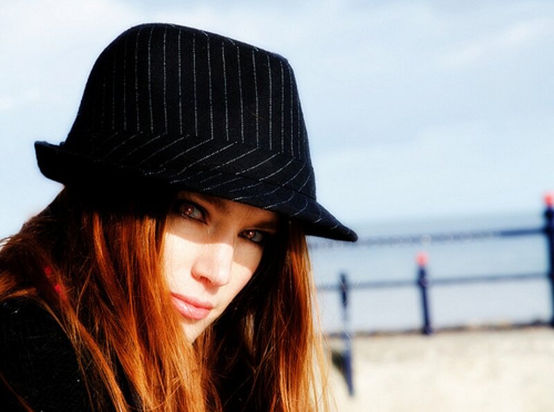woman in pinstripe hat at beach