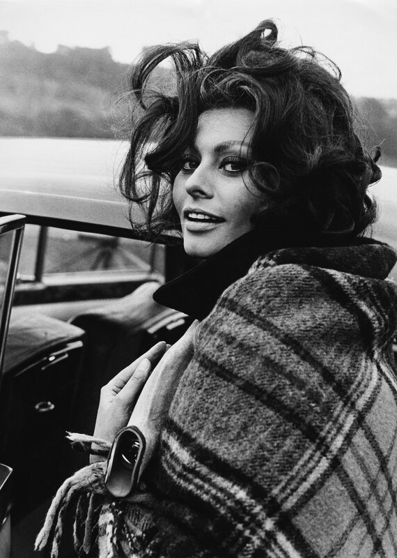 Woman in plaid coat by car