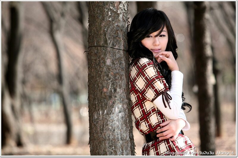 woman in plaid dress by tree