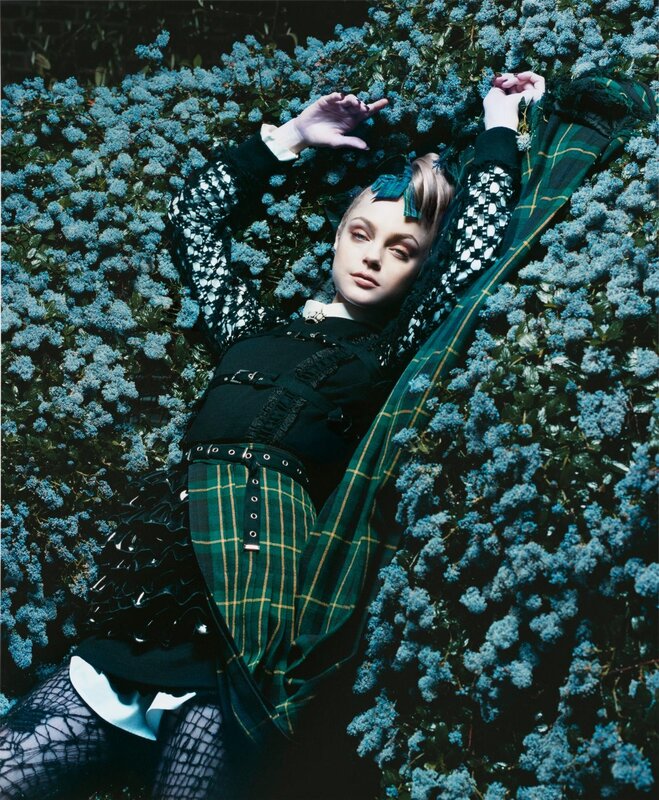 woman in plaid outfit lying in flowers