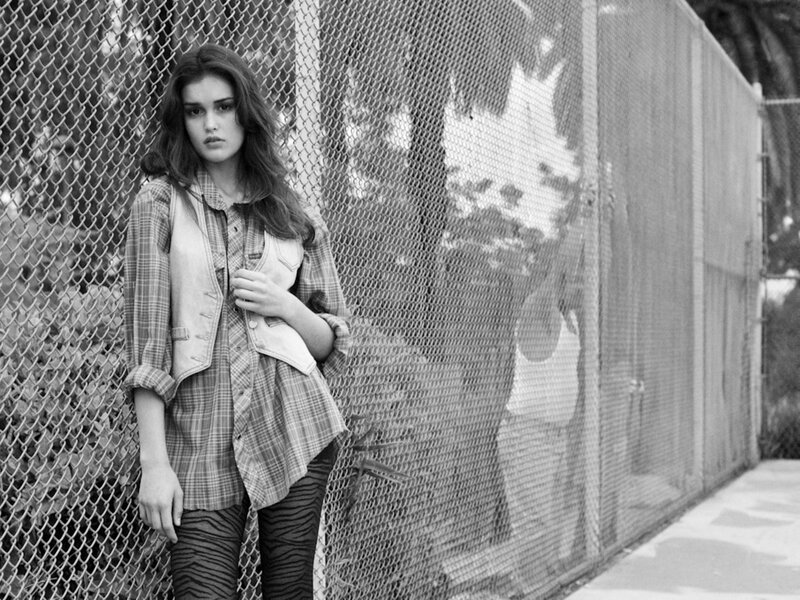 woman in plaid shirt by fence