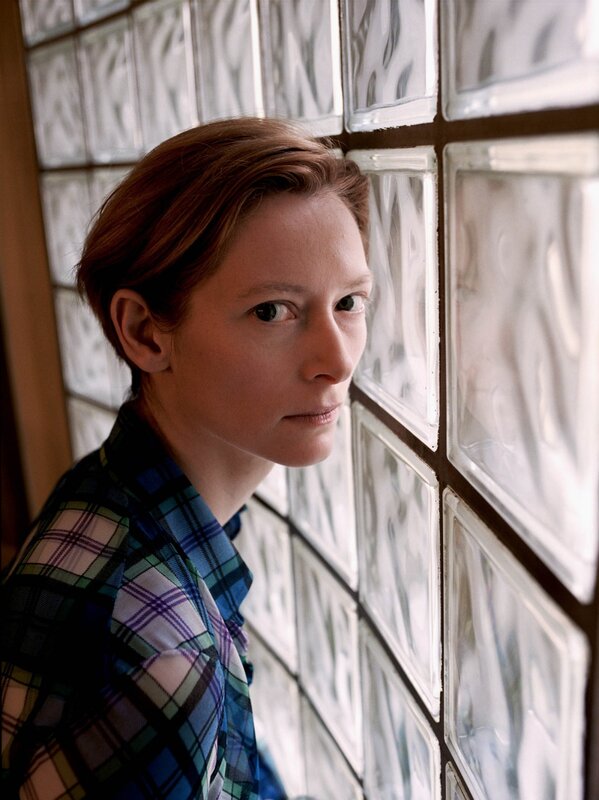 woman in plaid shirt by glass block wall