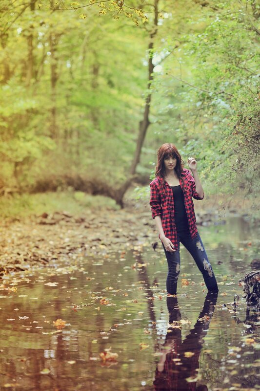woman in plaid shirt by stream