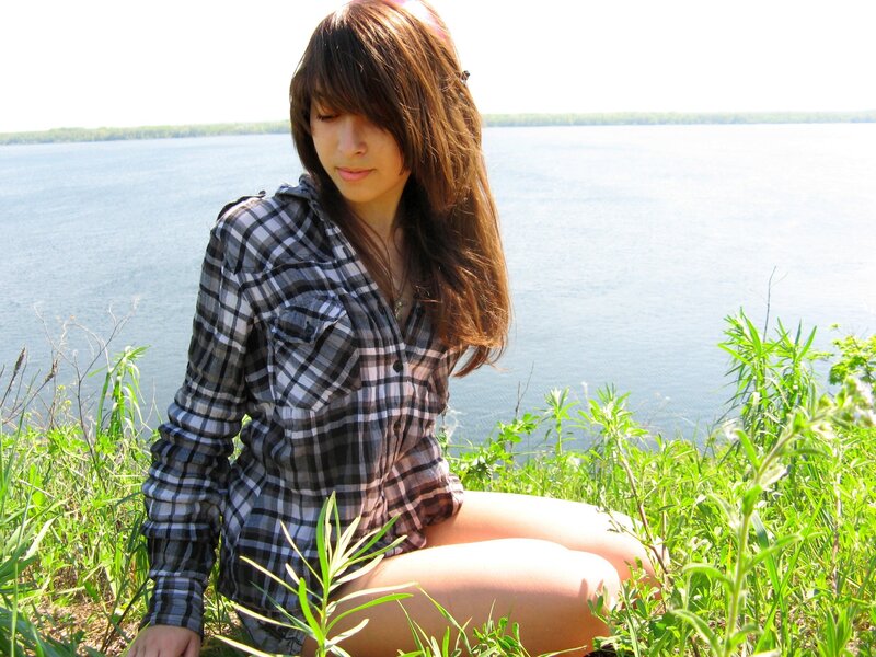 Woman in plaid shirt by the lake